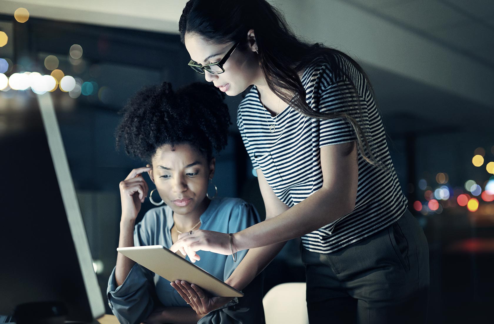 Two-woman-consult-tablet-inlate-night-office