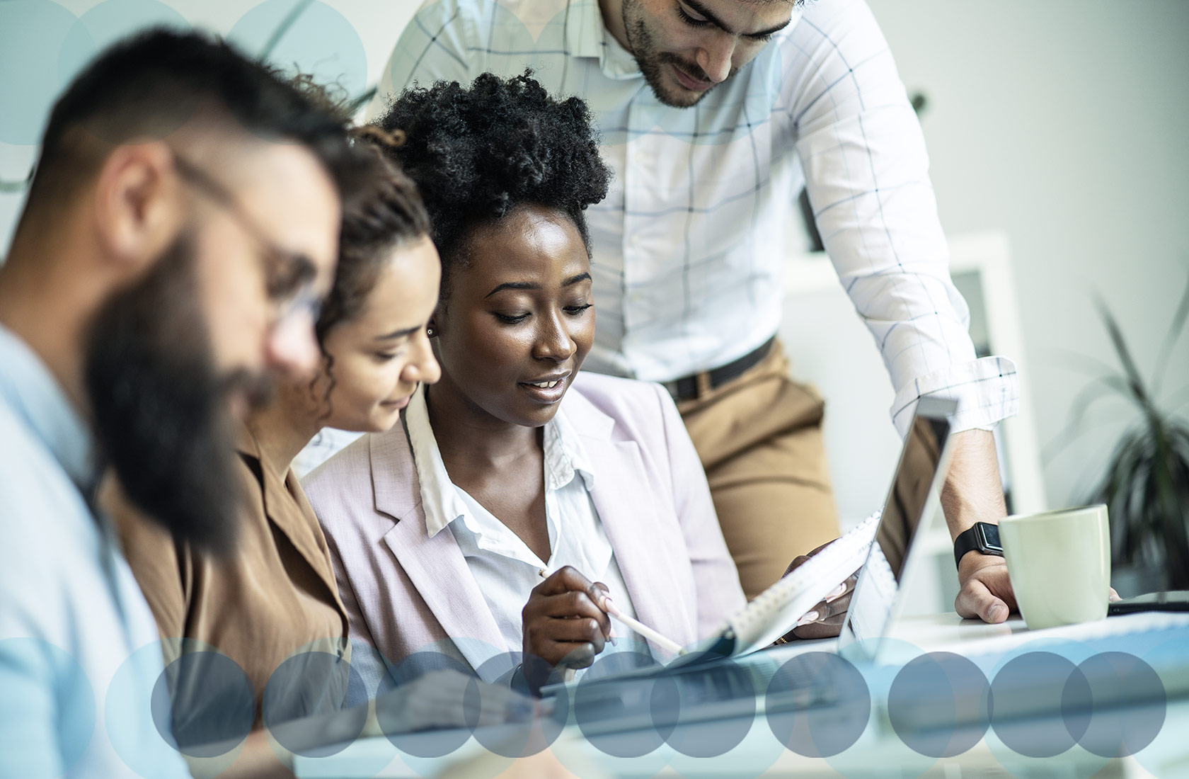 A multi-racial group of colleague discuss idea at a modern office table